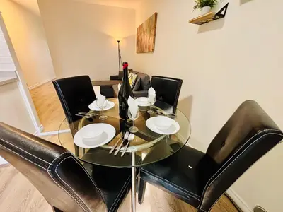 a glass dining room table with black leather chairs at Heart of the City Stay in Montréal