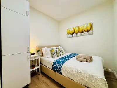 a small bedroom with two beds and a refrigerator at Heart of the City Stay in Montréal