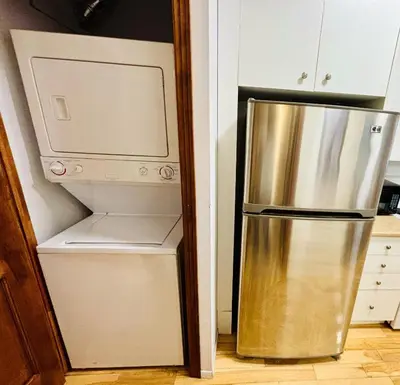 a stainless steel refrigerator in a kitchen next to a microwave at Freshly Renovated Stay in Montréal
