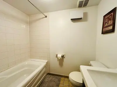 a bathroom with a tub and a toilet and a sink at Freshly Renovated Stay in Montréal