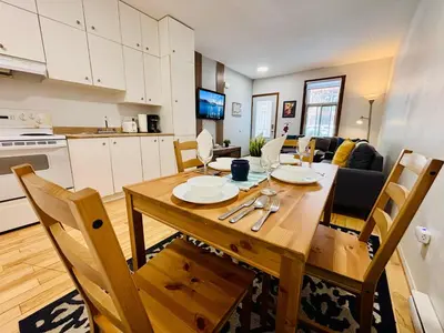 a kitchen and dining room with a wooden table and chairs at Freshly Renovated Stay in Montréal