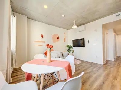 a dining room with a table and white chairs at Terracotta 1-BD in Downtown MTL in Montréal