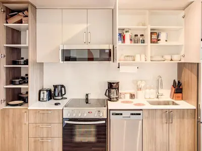a kitchen with white appliances and wooden cabinets at Terracotta 1-BD in Downtown MTL in Montréal