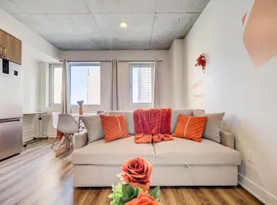 a living room with a couch with orange pillows at Terracotta 1-BD in Downtown MTL in Montréal