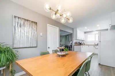 a kitchen with a wooden table and a refrigerator at Three bedroom apartment Free parking EV charger in Longueuil