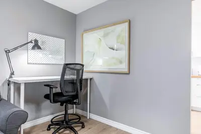 a desk with a chair and a lamp in a room at Three bedroom apartment Free parking EV charger in Longueuil