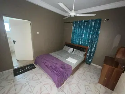 a bedroom with a purple bed and a ceiling fan at Cozy Home in Montréal