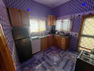 a kitchen with purple walls and wooden cabinets at Big Home in Montréal