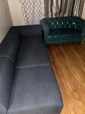 a couch sitting in a living room with a rug at Chambre a louer in Montréal