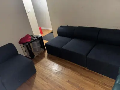 a living room with a couch and a chair at Chambre a louer in Montréal