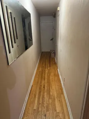 an empty hallway with a wooden floor and a mirror at Chambre a louer in Montréal