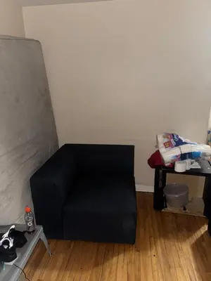 a black couch in a room with a table at Chambre a louer in Montréal