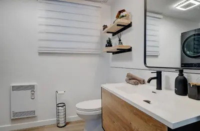 a bathroom with a toilet and a sink and a mirror at CHALET Le HAVRE NATURE SPA in Mansonville