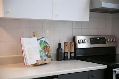 a kitchen counter with a stove and a bottle of wine at CHALET Le HAVRE NATURE SPA in Mansonville