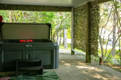 a large pool table sitting on a porch with a stool at CHALET Le HAVRE NATURE SPA in Mansonville