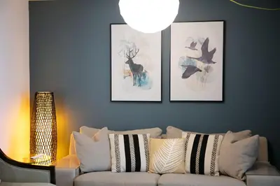 a living room with a couch and three pictures on the wall at CHALET Le HAVRE NATURE SPA in Mansonville