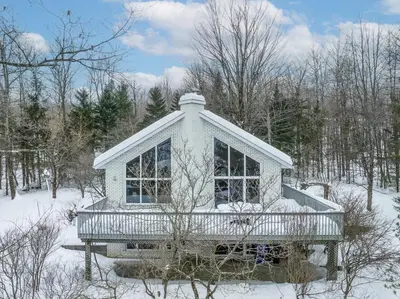 a small house in the snow in the woods at CHALET Le HAVRE NATURE SPA in Mansonville