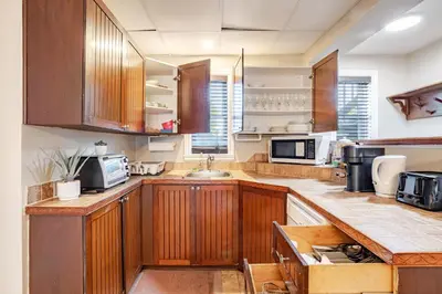 a large kitchen with wooden cabinets and a sink at Grande maison moderne 4 chambres - Spa Jaccuzi, Jardin & Parking gratuit - Idéale Familles et groupes in Saint-Jean-sur-Richelieu