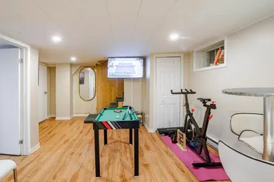 a room with a ping pong table and exercise equipment at Grande maison moderne 4 chambres - Spa Jaccuzi, Jardin & Parking gratuit - Idéale Familles et groupes in Saint-Jean-sur-Richelieu