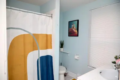 a bathroom with a shower curtain and a toilet at Grande maison moderne 4 chambres - Spa Jaccuzi, Jardin & Parking gratuit - Idéale Familles et groupes in Saint-Jean-sur-Richelieu
