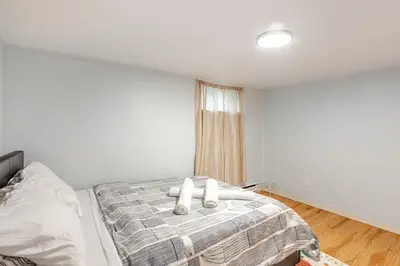 a bedroom with a bed with two white pillows at Grande maison moderne 4 chambres - Spa Jaccuzi, Jardin & Parking gratuit - Idéale Familles et groupes in Saint-Jean-sur-Richelieu