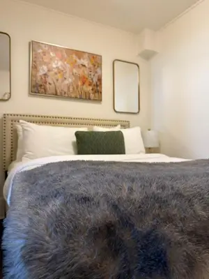 a bedroom with a large bed with two mirrors at Authentic Spacious 1BDR In Downtown Montreal in Montréal