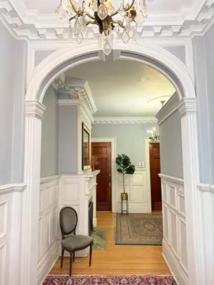 an archway in a room with a chair and a chandelier at Authentic Spacious 1BDR In Downtown Montreal in Montréal