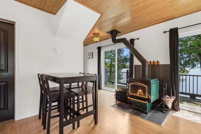 a kitchen with a wood stove and a table at Havre du Huit in Adstock