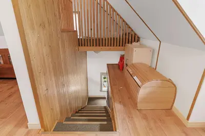 a staircase with a wooden bench in a house at Havre du Huit in Adstock