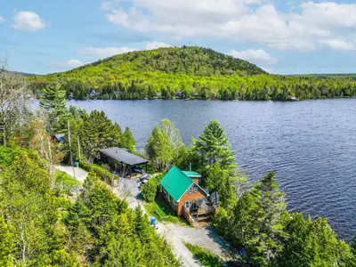 an aerial view of a house on the shore of a lake at Havre du Huit in Adstock