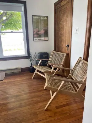 two chairs sitting in a room with a window at Grande Maison Vintage à Ange Gardien Sortie 55 Autoroute 10 in Ange-Gardien