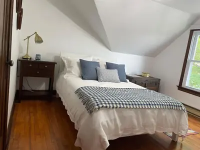 a bedroom with a bed with blue and white pillows at Grande Maison Vintage à Ange Gardien Sortie 55 Autoroute 10 in Ange-Gardien