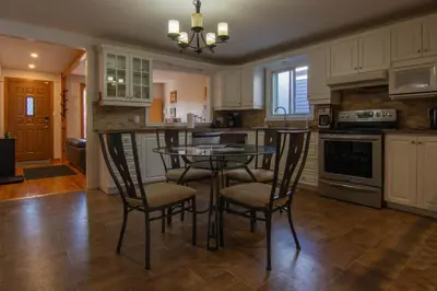 a kitchen with a table and chairs in it at Cozy Bungalow Longueuil - 3 BR - 6 pers in Longueuil