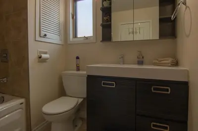 a bathroom with a toilet and a sink and a mirror at Cozy Bungalow Longueuil - 3 BR - 6 pers in Longueuil