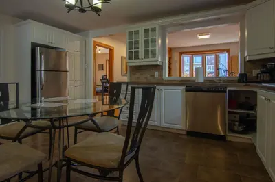 a kitchen with a table and chairs and a refrigerator at Cozy Bungalow Longueuil - 3 BR - 6 pers in Longueuil