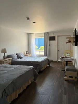 a hotel room with two beds and a couch at Motel Le Villageois Du Lac in Saint-Francois-du-Lac
