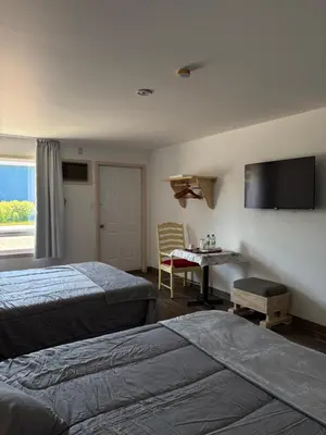 a hotel room with two beds and a television at Motel Le Villageois Du Lac in Saint-Francois-du-Lac