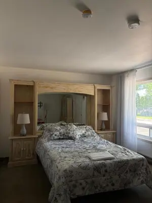 a bedroom with a bed and two lamps and a window at Motel Le Villageois Du Lac in Saint-Francois-du-Lac