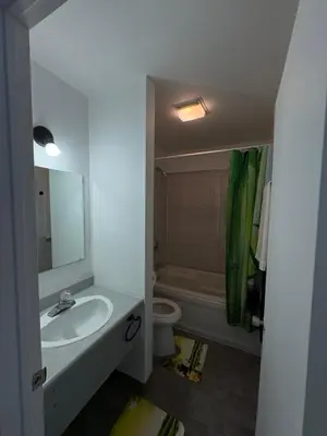 a bathroom with a sink and a toilet and a mirror at Motel Le Villageois Du Lac in Saint-Francois-du-Lac