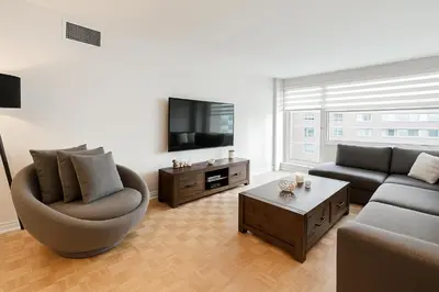 a living room with a couch and a tv at Golden Mile Luxe Apartment in Montréal
