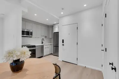 a kitchen with a table with a vase of flowers on it at Le Victoria Midtown Mtl in Montréal