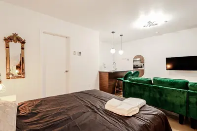a bedroom with a green bed and a couch at Escapade Chic au Vieux-Port in Montréal