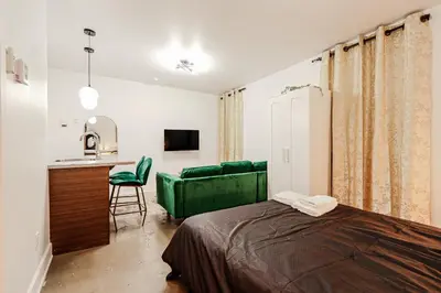 a bedroom with a green bed and a kitchen at Escapade Chic au Vieux-Port in Montréal