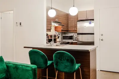 a kitchen with green chairs at a kitchen counter at Escapade Chic au Vieux-Port in Montréal