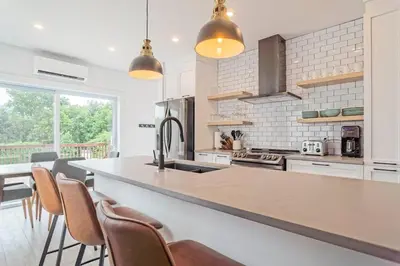 a kitchen with a sink and a counter with chairs at 851 condo in Bromont Vieux Village mountain view in Bromont