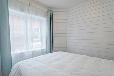 a white bedroom with a bed and a window at 851 condo in Bromont Vieux Village mountain view in Bromont