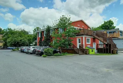 a red house with cars parked in a parking lot at 851 condo in Bromont Vieux Village mountain view in Bromont