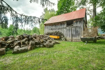 a pile of logs in front of a barn at 853 condo in Bromont Vieux Village mountain view in Bromont