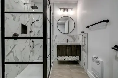 a bathroom with a shower and a sink and a mirror at Most beautiful condo 101 in Bromont Vieux in Bromont