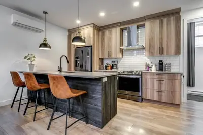 a kitchen with wooden cabinets and a island with bar stools at Most beautiful condo 101 in Bromont Vieux in Bromont